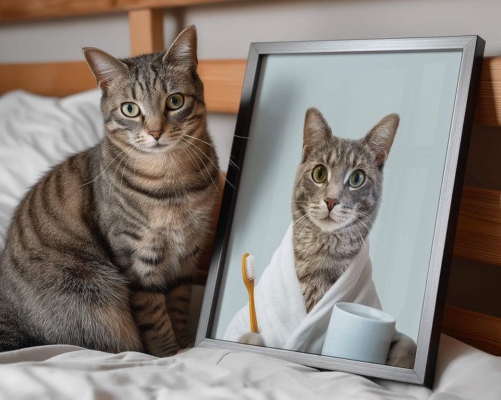 Custom cat bathroom picture of a tabby cat wearing a white bathrobe and holding a toothbrush next to the real cat on a bed.