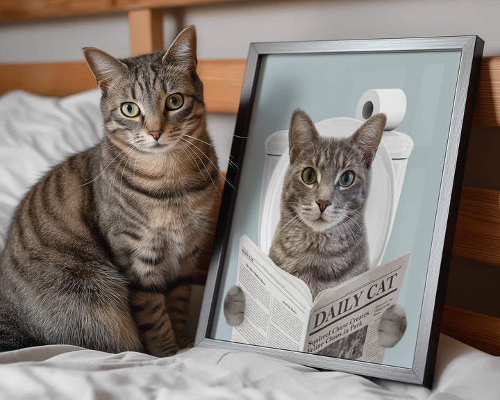 Hilarious custom cat bathroom art showing a cat reading a newspaper while sitting on a toilet next to the real cat.