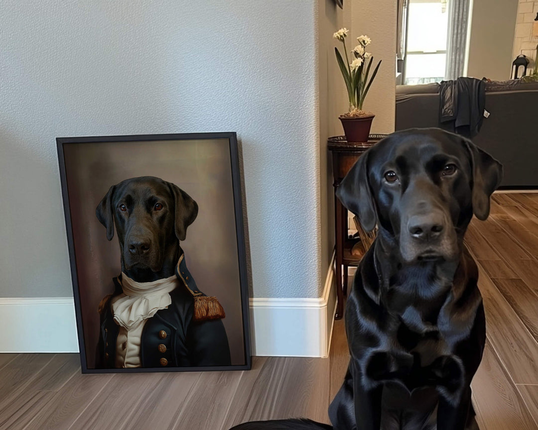 A black Labrador sitting beside a framed portrait of itself dressed in a historical military uniform.